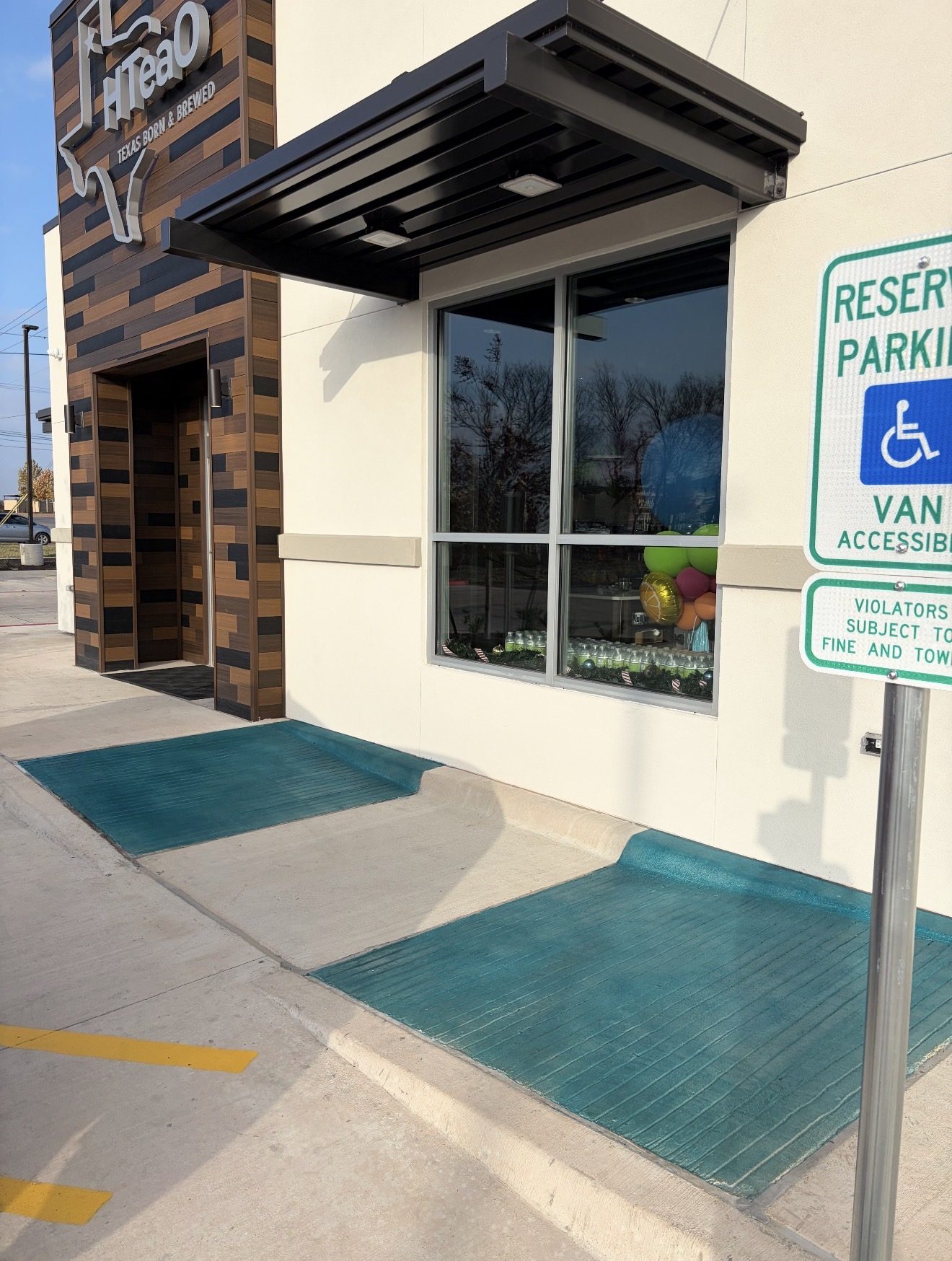 Teal stamped concrete entry ramp, HTeaO drive-thru